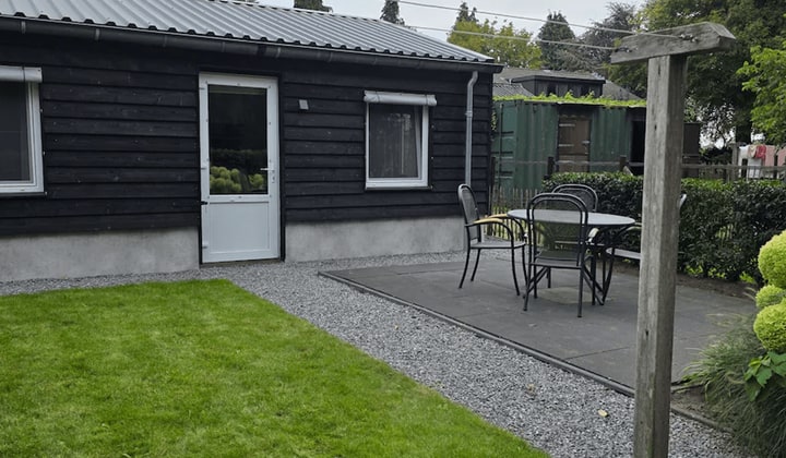 Houten huisje met tuin en parkeerplek