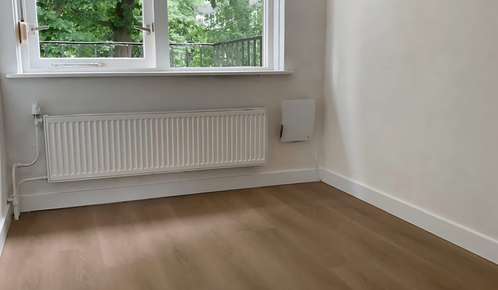 Gestoffeerde kamer met wasmachine en nette keuken