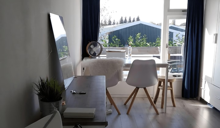 Gestoffeerde studentenkamer met balkon en wasmachine