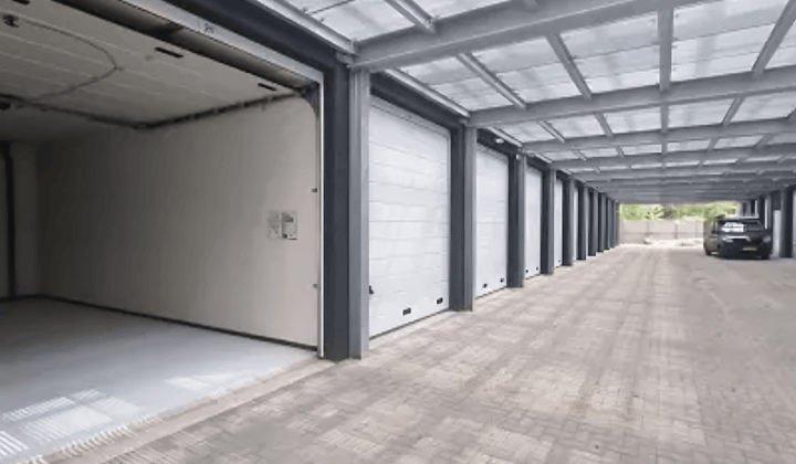 Bedrijfsruimte met elektrische overheaddeur en epoxyvloer