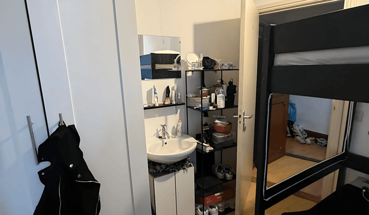 Gemeubileerde studentenkamer met wasbak en gedeelde voorzieningen